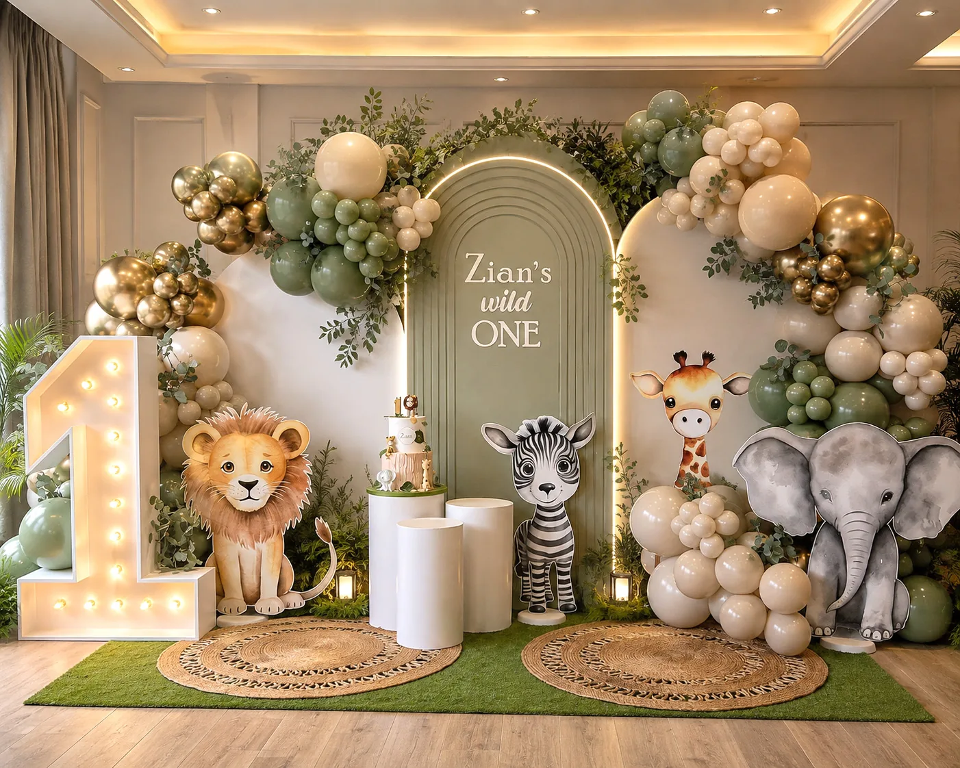 The same hall styled by The Party Genie as a jungle-theme first birthday, with balloon garlands, an arch backdrop and a lit number one